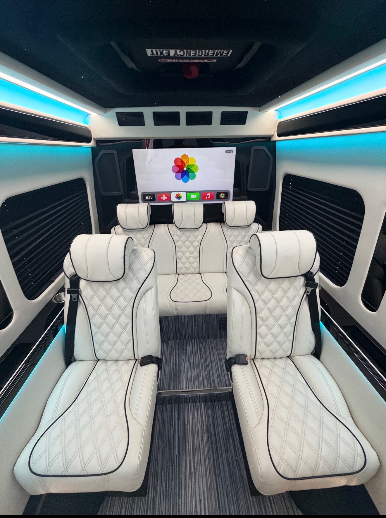 White diamond-quilted leather seats with black piping in a van cabin under blue lighting