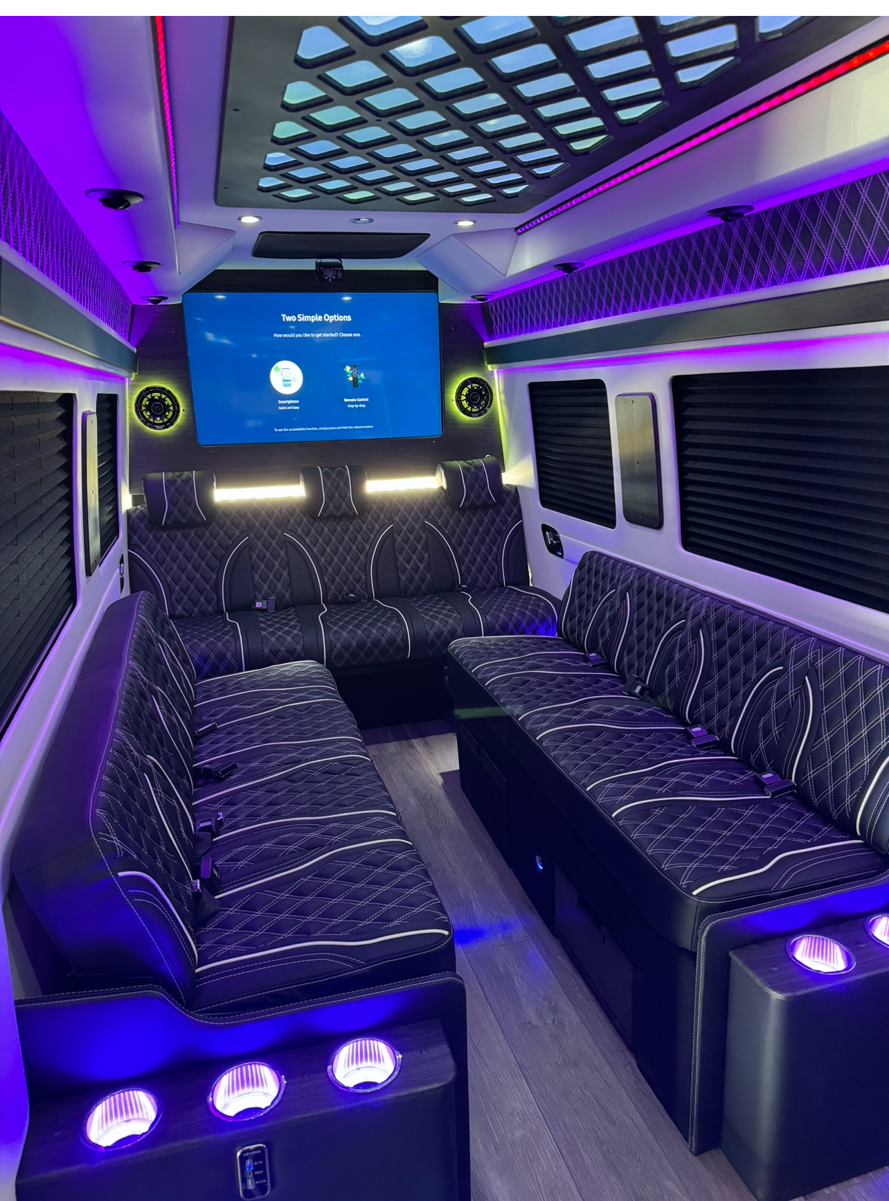 Perimeter black leather bench seating with white diamond stitching under purple accent lighting